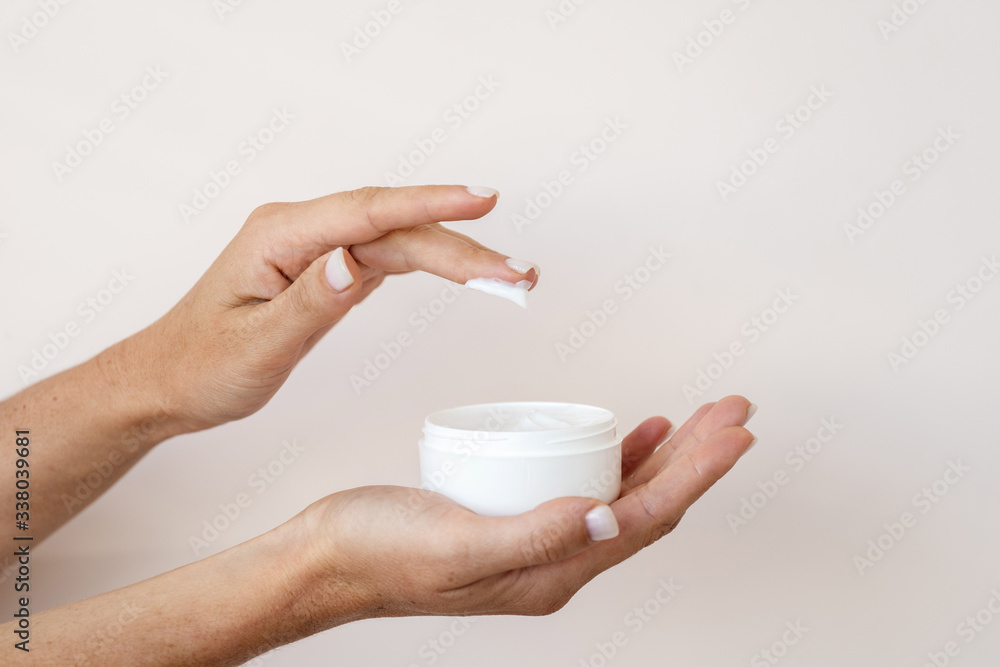 Φωτογραφία Young adult girl holding container with bodycare and skincare cream