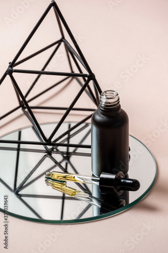 Black glass bottle with pipette and anti aging serum oil