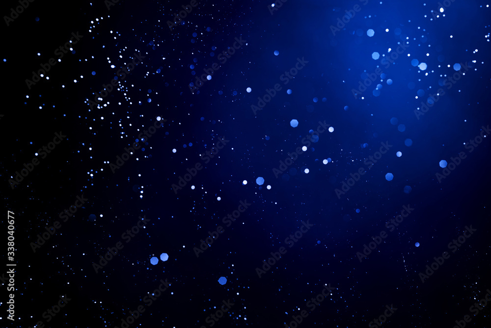 Obraz premium Abstract dark background with glowing blue particles.