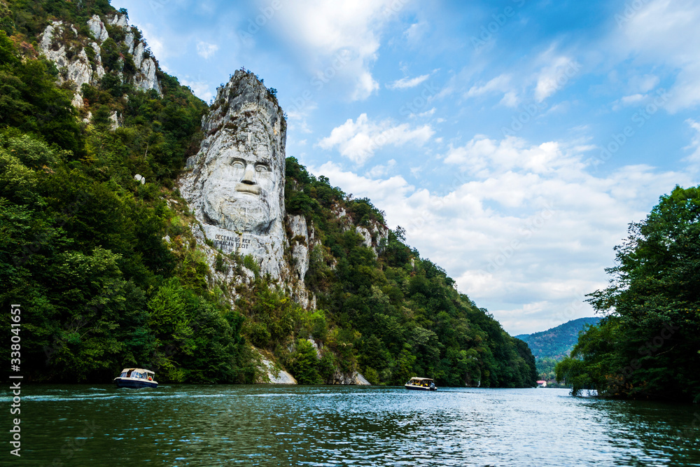 The face of the Dacian king Decebal. Panoramic view of the Danube river.  - obrazy, fototapety, plakaty 