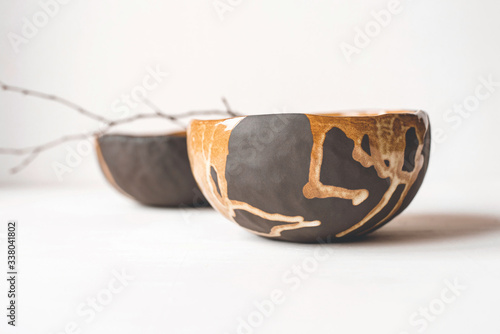 Handmade ceramics in the style of wabi sabi. Brown clay bowls with an abstract pattern. photo