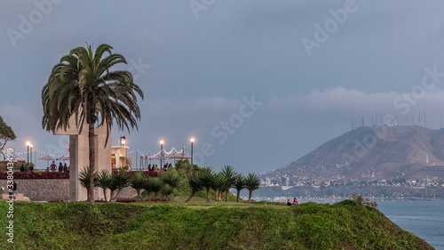 Intihuatana park with panoramic view of Miraflores district and Morro Solar hill on a background day to night timelapse, in Lima, Peru