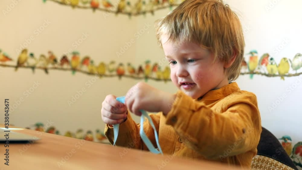 Little cute boy learning how to wear protective face mask at home spending time online with laptop. Sunny day. Healthcare concept. Quarantine isolation. Happy family with healthy children. Little cute boy learning how to wear protective face mask at home spending time online with laptop. Sunny day. Healthcare concept. Quarantine isolation. Happy family with healthy children.