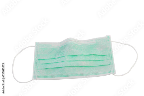 Protective face mask on wood table. Typical 3-ply surgical mask to cover the mouth and nose. Procedure mask from bacteria. Protection concept. Surgical mask with rubber ear straps. covid 19