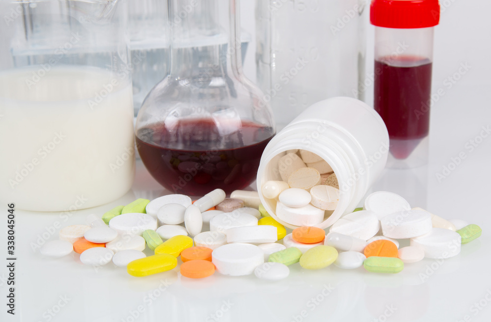 Medical pills and glassware with liquids for laboratory analysis ...