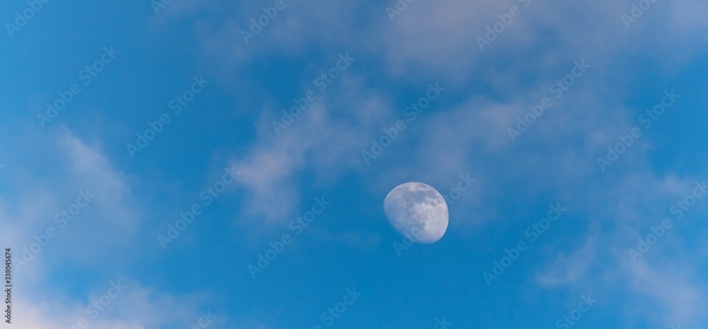 Three Quarter Moon in a Blue Sky with Clouds Three Quarter Moon in a Blue Sky with Clouds