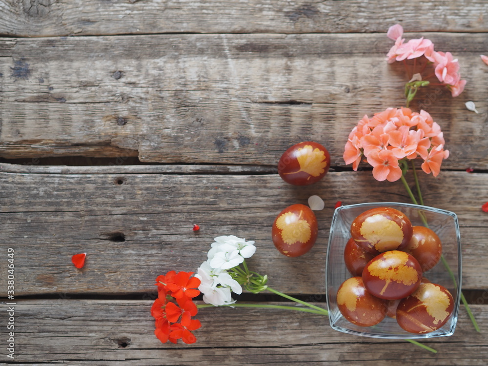 Easter.Place for text.Painted eggs in a glass plate with flowers on a wooden old background. Easter.Place for text.Painted eggs in a glass plate with flowers on a wooden old background.