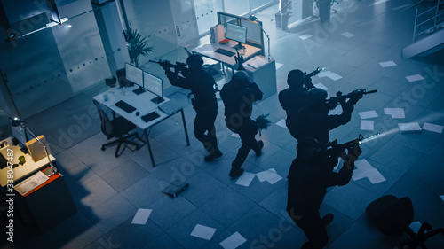 Tableau sur toile Masked Squad of Armed SWAT Police Officers Storm a Dark Seized Office Building with Desks and Computers