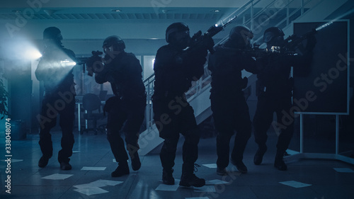 Wallpaper Mural Masked Team of Armed SWAT Police Officers Move in a Hall of a Dark Seized Office Building with Desks and Computers. Soldiers with Rifles and Flashlights Surveil and Cover Surroundings. Torontodigital.ca