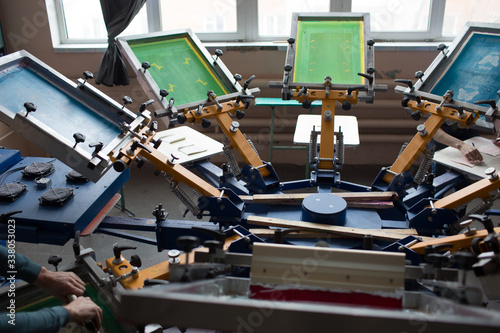 Silk screen printing. Serigraphy. Color paints and fabric. Carousel machine.