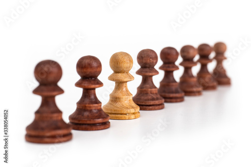Single white chess pawn in row with black chess pawns. Isolated on white. Thinking out of the box concept.