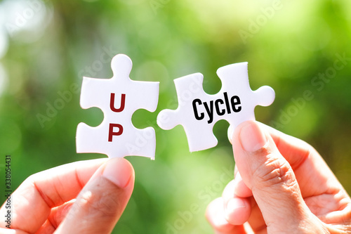 Upcycle (Reuse - discarded objects or material in such a way as to create a product of higher quality or value than the original) word on white jigsaw puzzle - match concept.