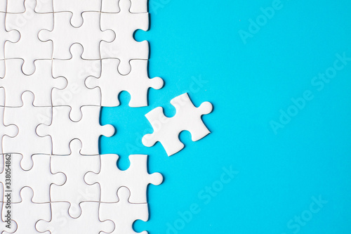 Many white jigsaw puzzle on blue background - idea solution concept.