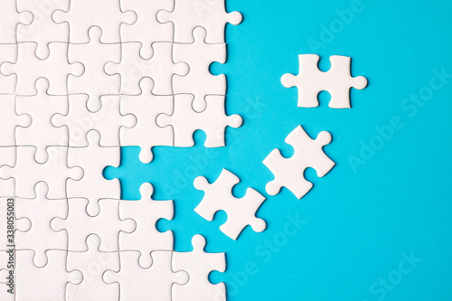 Many white jigsaw puzzle on blue background - idea solution concept. photo