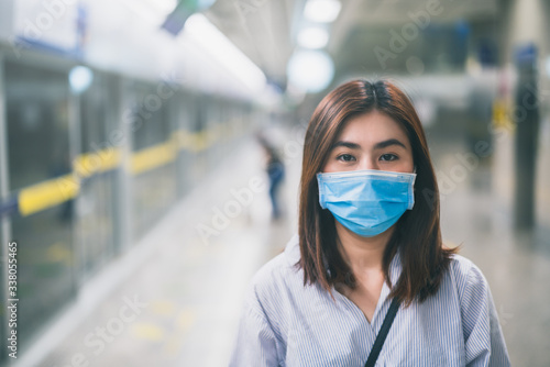 Young asian woman wearing protective face mask in subway due to the polluted air or pm 2.5 and Coronavirus disease or COVID-19 outbreak situation in all of landmass in the world.