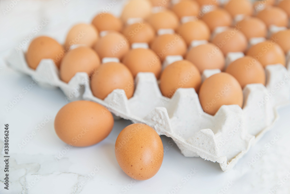 Close-up view of raw chicken eggs in egg box on wooden background. Raw chicken eggs in egg box organic food for good health high protein . Close-up view of raw chicken eggs in egg box on wooden background. Raw chicken eggs in egg box organic food for good health high protein .