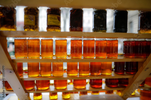 Shallow depth of field (selective focus) image with jars full of honey on sale in a traditional Romanian market.