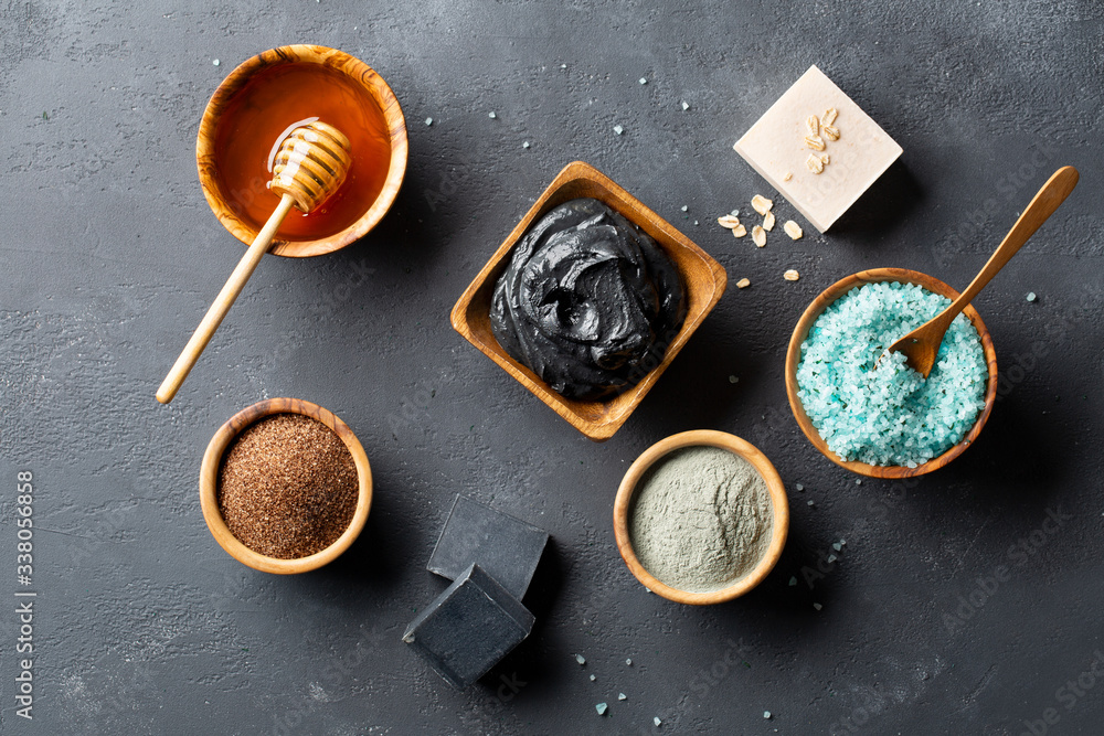 Spa. Natural cosmetics for the body and face. Blue sea salt with seaweed, soaps of herbs and dead sea mud, ground coffee scrub, honey, clay on a dark table. Top view. Copy space. Spa. Natural cosmetics for the body and face. Blue sea salt with seaweed, soaps of herbs and dead sea mud, ground coffee scrub, honey, clay on a dark table. Top view. Copy space.