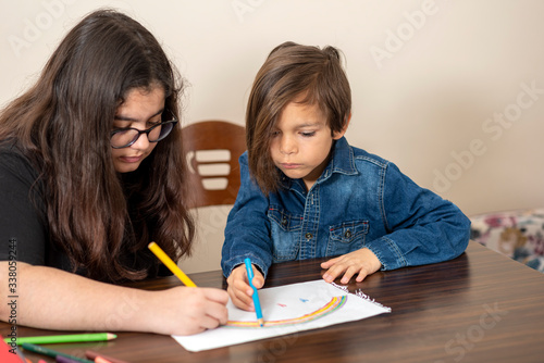 brother and sister draw rainbow on paper