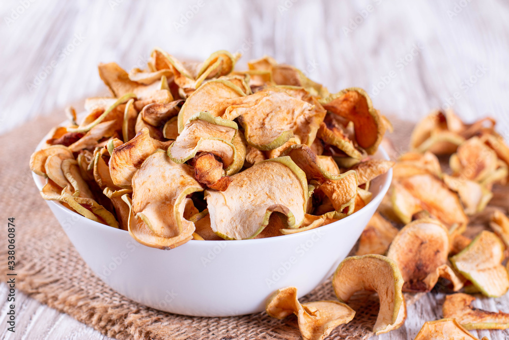 Homemade dried organic apple sliced in a white bowl Homemade dried organic apple sliced in a white bowl