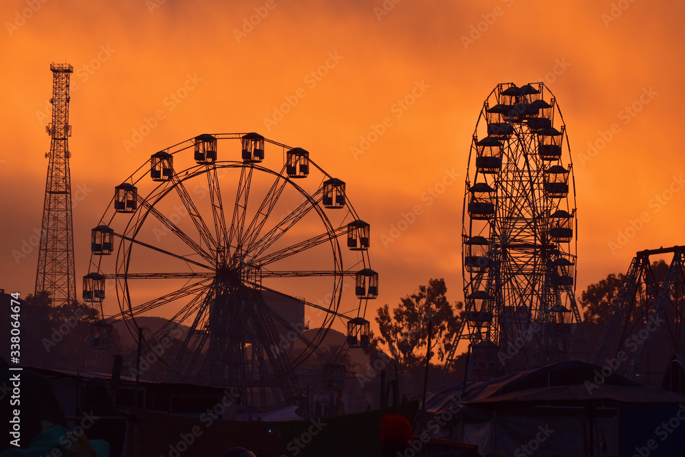 colorful sky silhouette of an amusement park with joy rides 