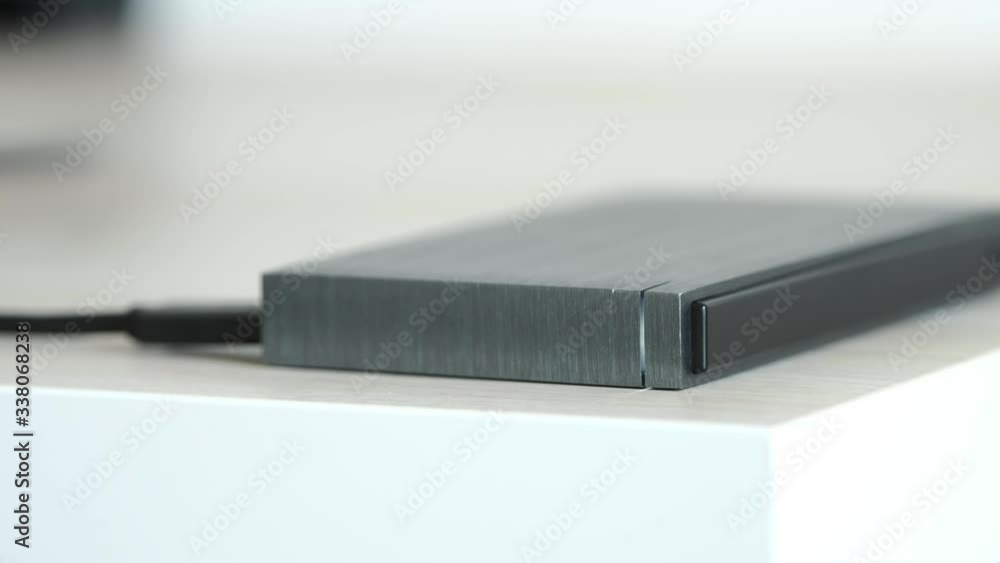 External Hard Drive On a Table, Led Light Flickering - Solid Aluminium Casing HDD, Minimalist Design Composition - Macro Closeup External Hard Drive On a Table, Led Light Flickering - Solid Aluminium Casing HDD, Minimalist Design Composition - Macro Closeup