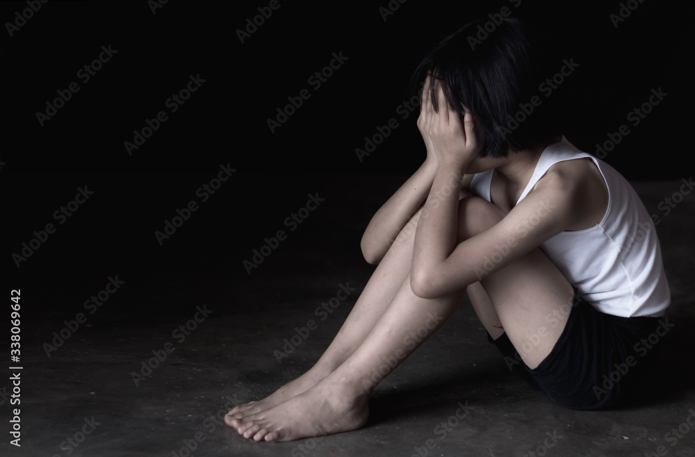 Sad little girl sitting alone on floor.traumatized children concept.stop violence and abused children. Sad little girl sitting alone on floor.traumatized children concept.stop violence and abused children.