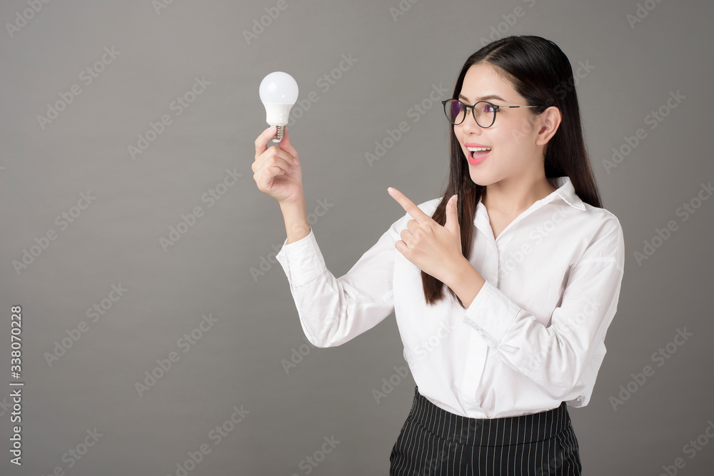 Beautiful intelligent woman is holding light bulb in studio Beautiful intelligent woman is holding light bulb in studio