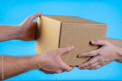 Two hands taking a box gift on blue background