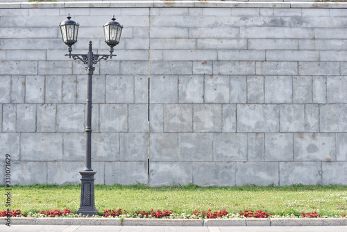 vintage lightpost near the grey wall and green grass
