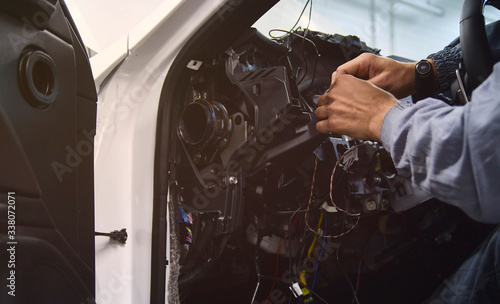 Fotografie mechanic or technician fixing or repairing car interior wire system