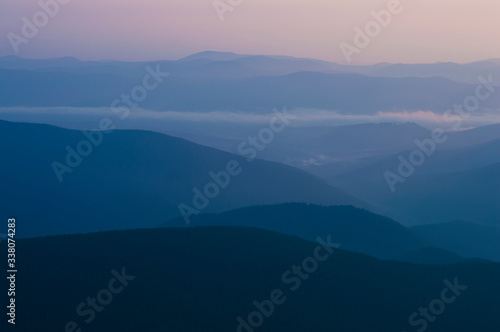 silhouette mountains in the haze at sunset time © Serhii  Holdin