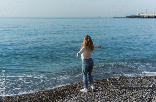 a girl with red hair walks on the beach