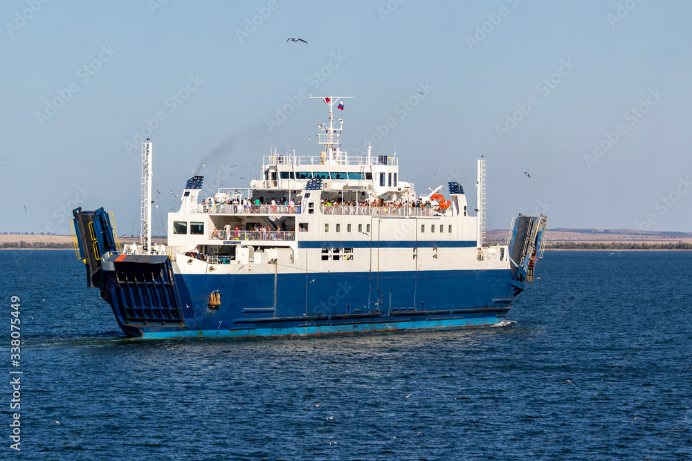 Ferry transports people and cars on a Sunny day