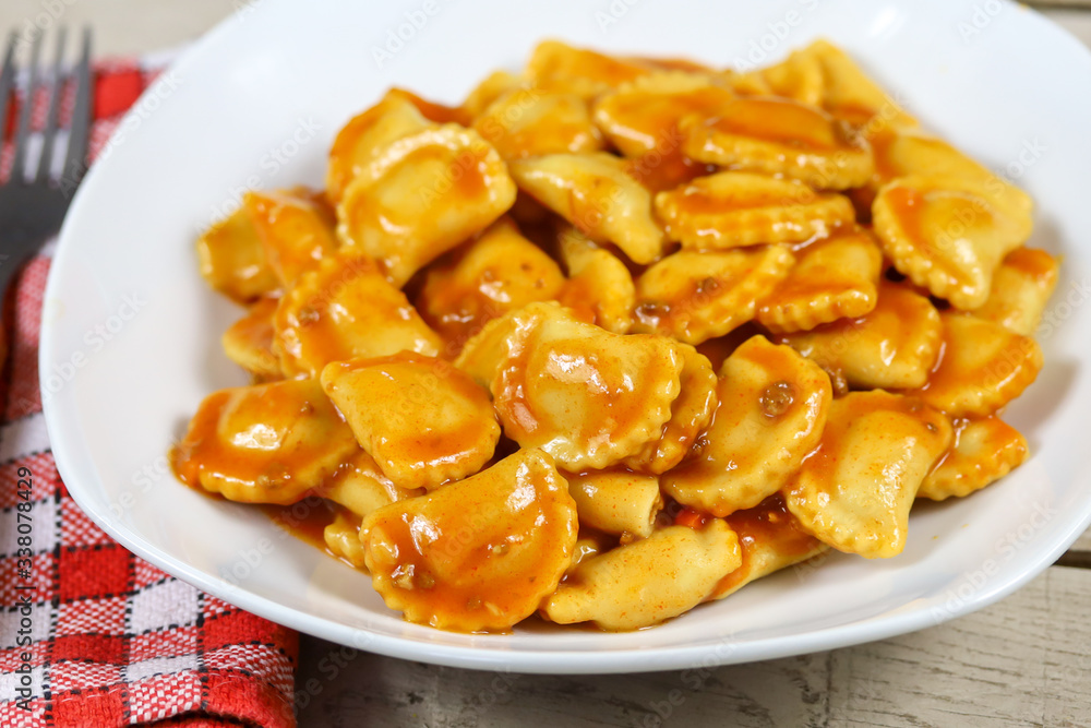 assiette de raviolis à la sauce tomate sur une table en bois assiette de raviolis à la sauce tomate sur une table en bois