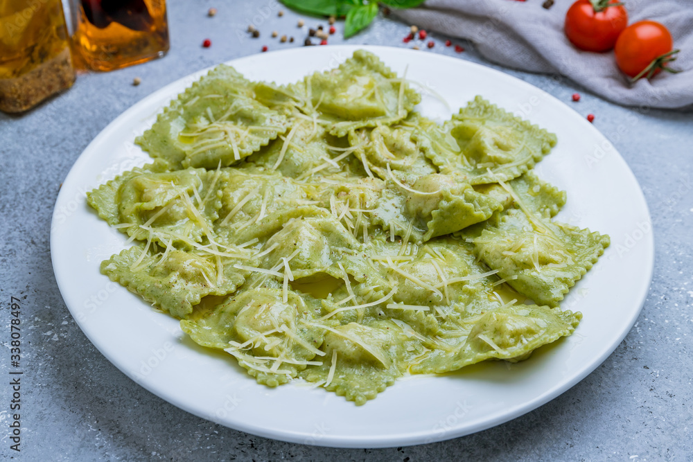 Green ravioli with spinach on white plate