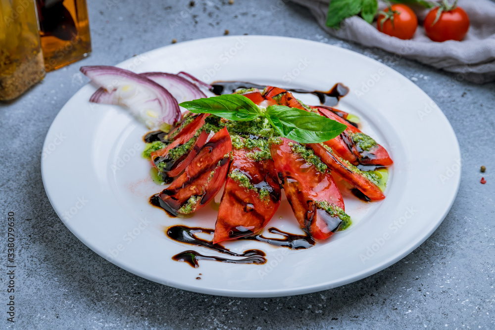 Caprese salad with mozzarella and tomato on white plate Caprese salad with mozzarella and tomato on white plate