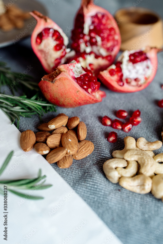 Pomegranate fruit, walnuts, cashew nuts on the table - healthy food products Pomegranate fruit, walnuts, cashew nuts on the table - healthy food products