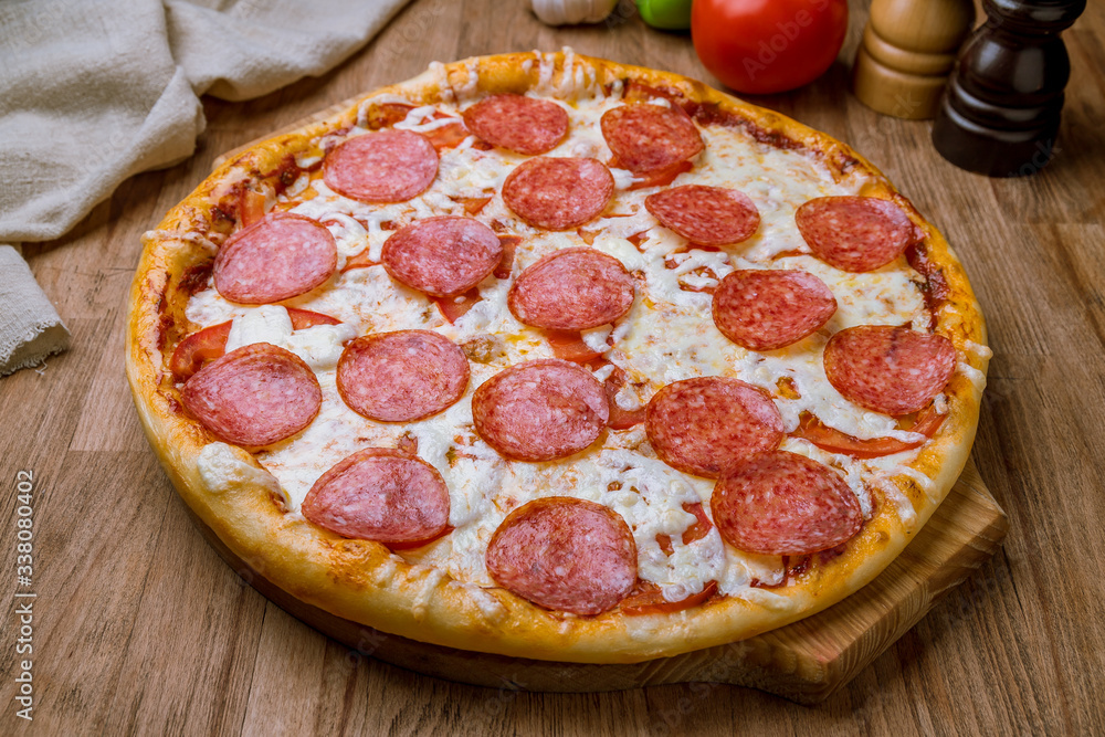 Pepperoni pizza on the board on wooden table