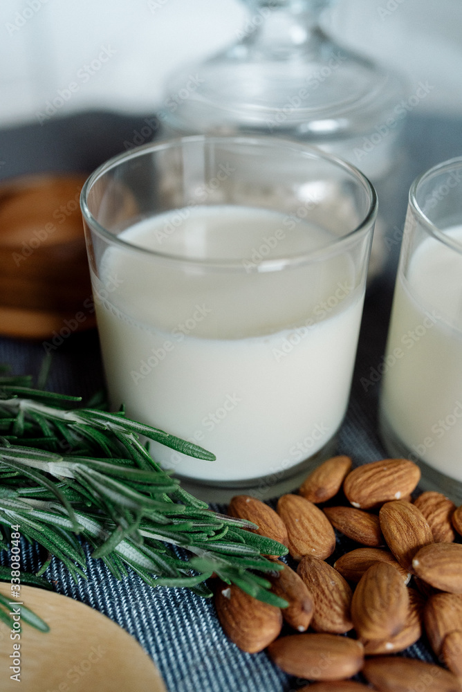 Almond milk in a glass with almonds and rosemary Almond milk in a glass with almonds and rosemary
