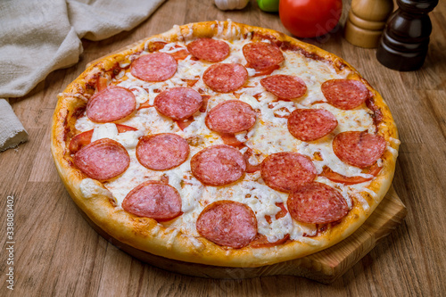 Pepperoni pizza on the board on wooden table