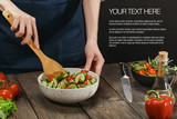 Woman mixing fresh vegetable salad. Female hands. Diet concept for healthy lifestyle with sample text.