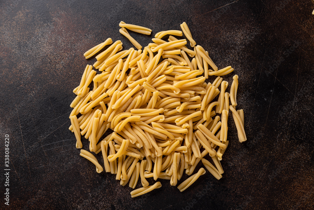 Close-up of uncooked treccia pasta on a dark texture background. food background. top view. copy space.