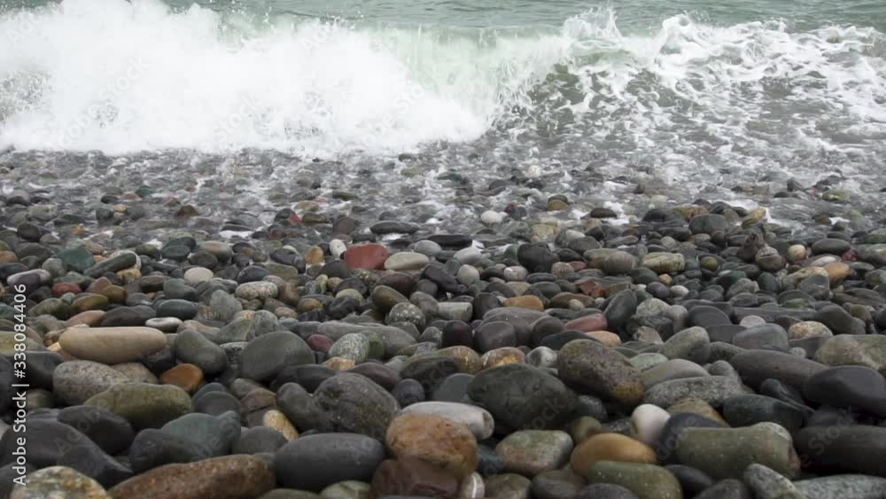 Sea waves roll on pebbles shore during a light storm close up slow motion slow motion Sea waves roll on pebbles shore during a light storm close up slow motion slow motion