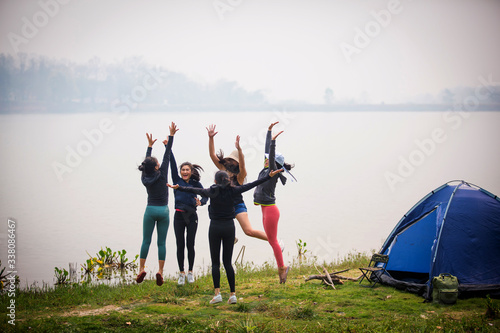 A group of Asian women camping and have fun camping on the lake in a national park for a holiday.