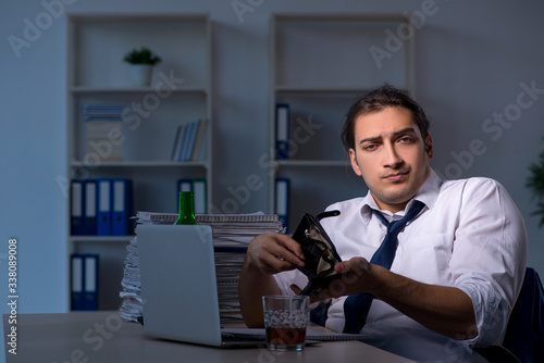 Alcohol addicted businessman working late in the office
