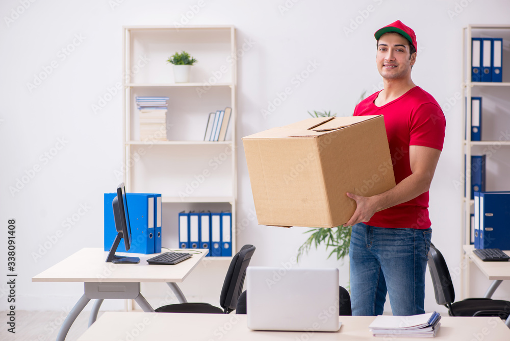 Young male courier delivering postbox to the office Young male courier delivering postbox to the office