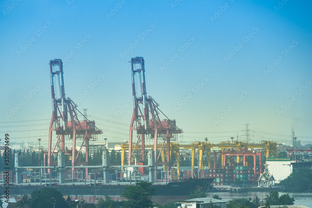 crane in port for lifting container for overseas transportation on blue sky background with copy space