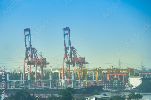 crane in port for lifting container for overseas transportation on blue sky background with copy space