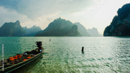 traditional wooden Thai long tail boat with beautiful landscape mountain ranges background at “Cheow Lan Dam (Ratchaprapa Dam)” Suratthani Thailand...